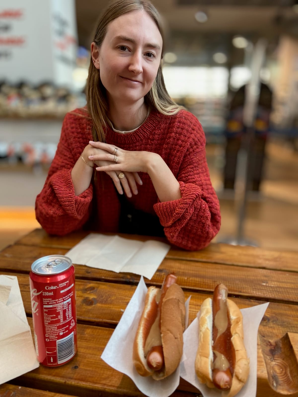 Two Icelandic hot dogs with everything and a Coke on a wooden table