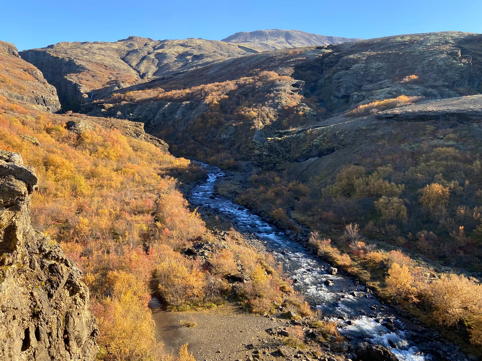 The autumn river valley climbing toward Glymur at the head of Botnsdalur