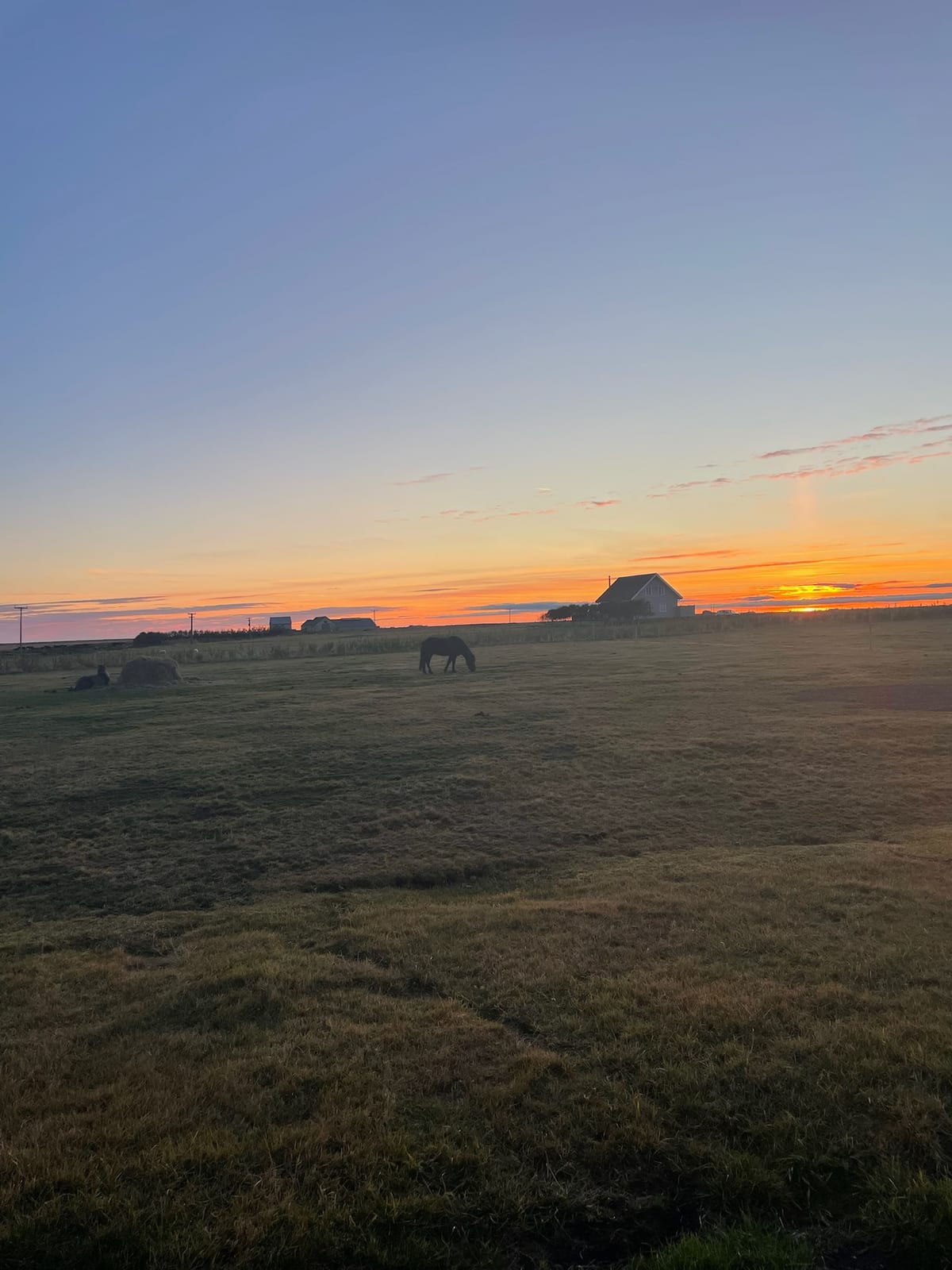 Sunset over the horse farm and the flat south coast at Landeyjar