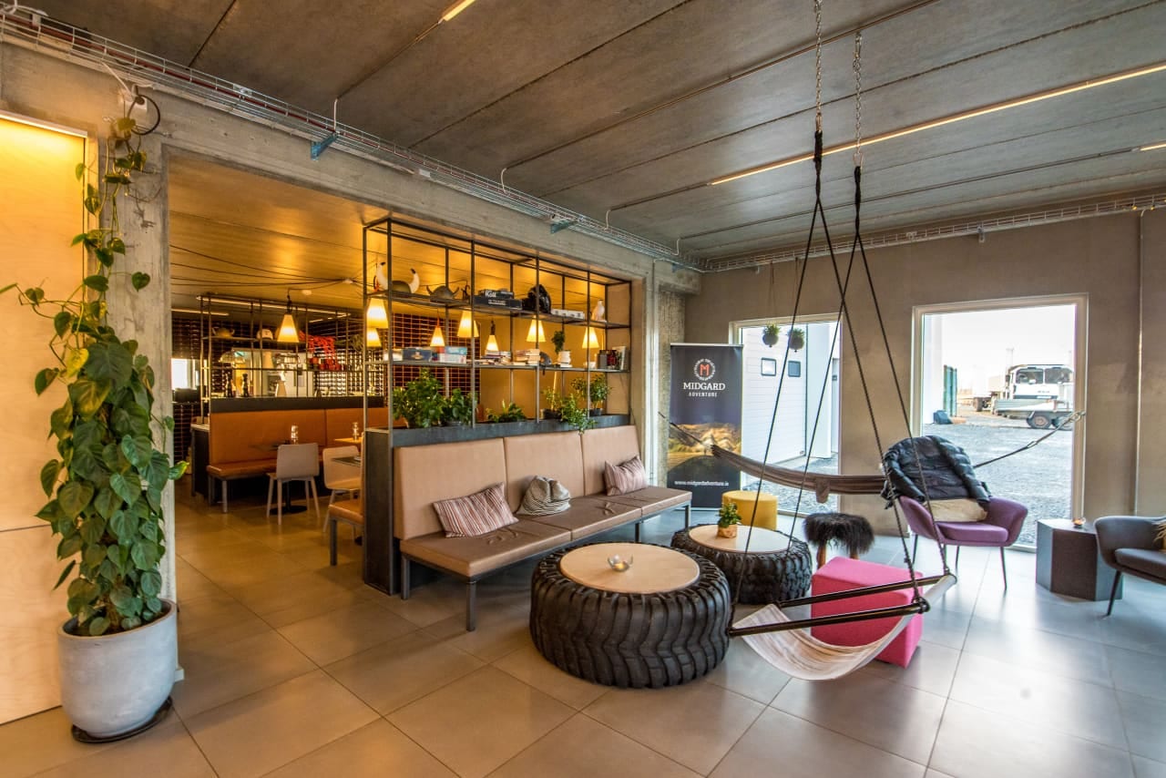 The Midgard Base Camp lounge — hammock swings, tractor-tire tables, and a warm bar behind