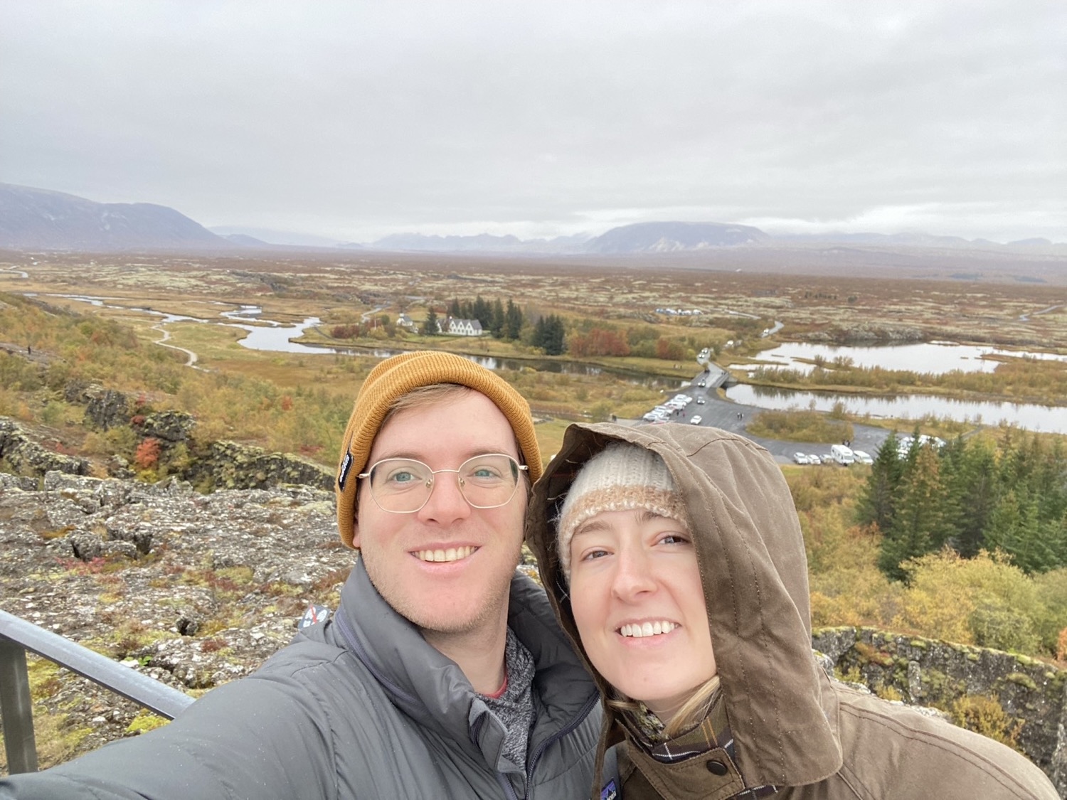 Two travelers above the Thingvellir rift, autumn colors and a lake behind