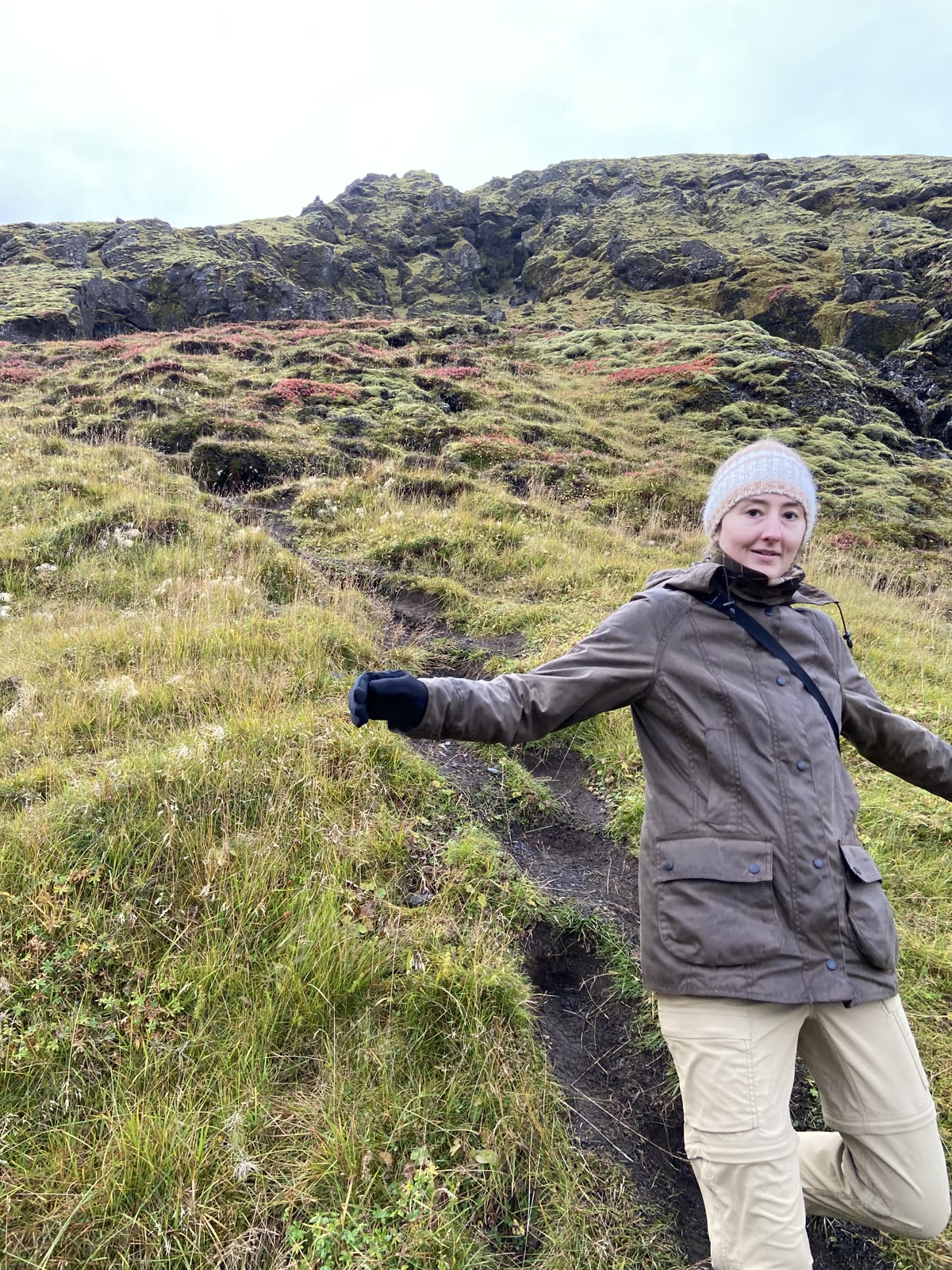 A hiker with arms out on a mossy Thorsmork trail