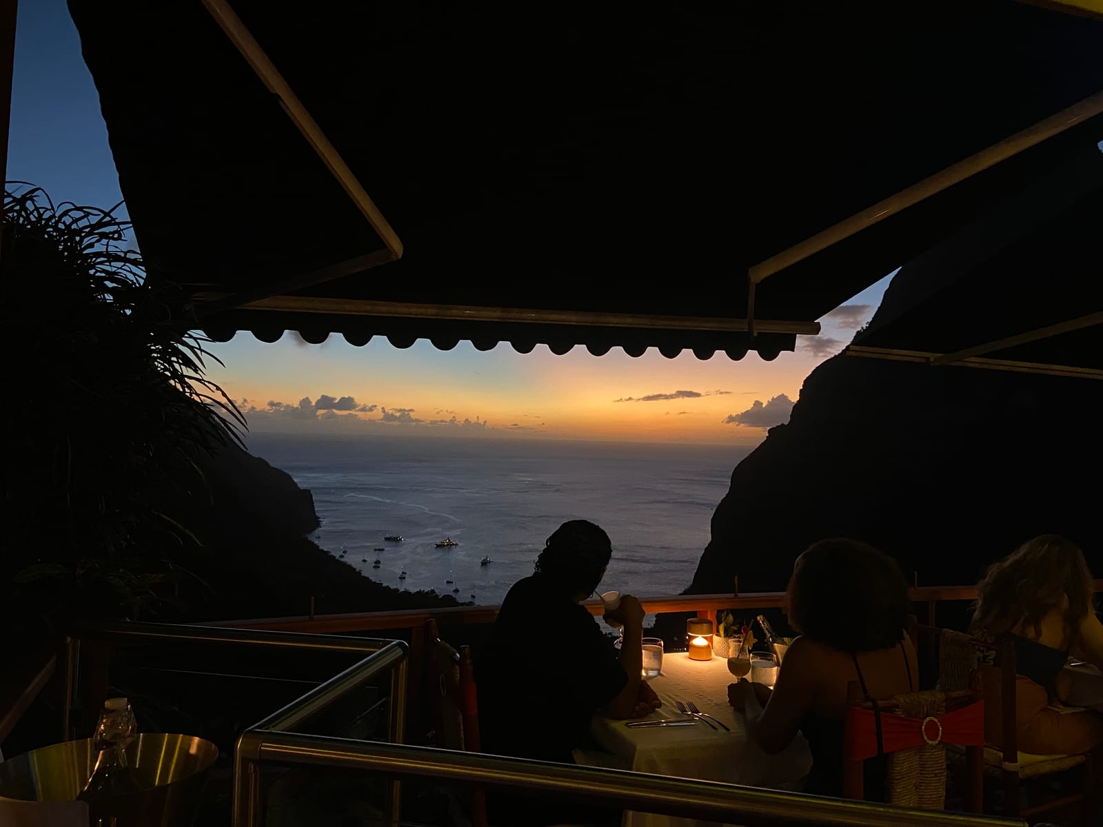 Diners in silhouette at Dasheene as the sky goes orange between the Pitons