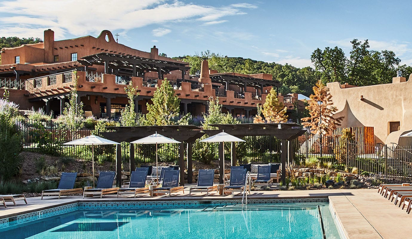 The outdoor pool at Bishop's Lodge below the adobe buildings and wooded foothills north of Santa Fe