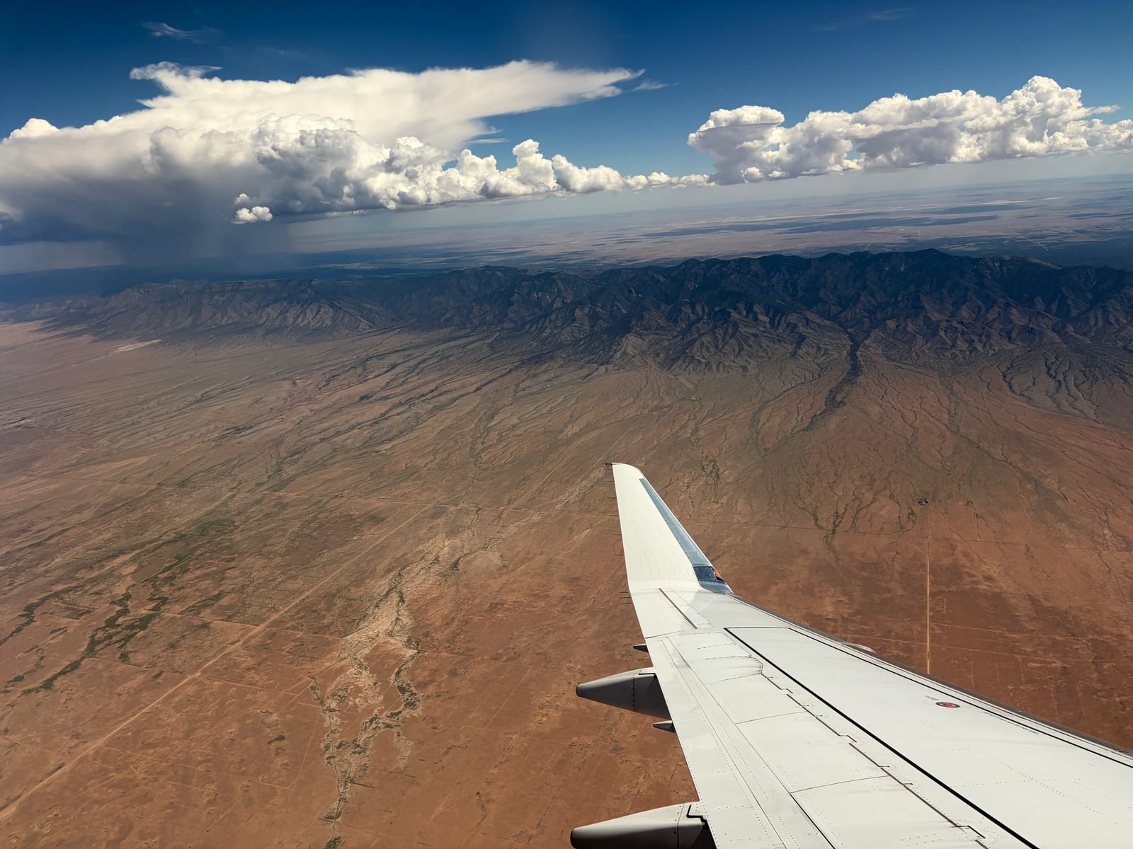 The high desert and a long mountain range seen from an aircraft window leaving Albuquerque