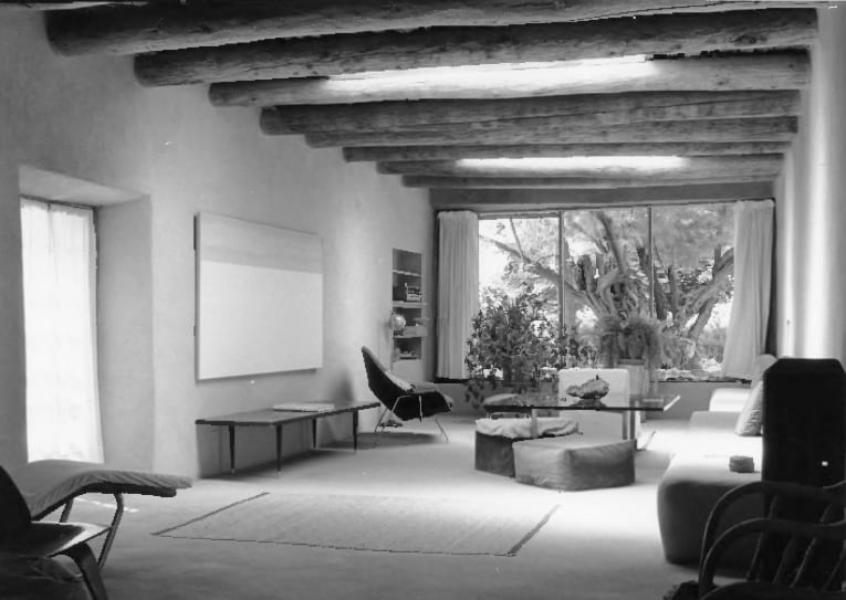 The living room of Georgia O'Keeffe's Abiquiu house, with viga beams and a wide picture window
