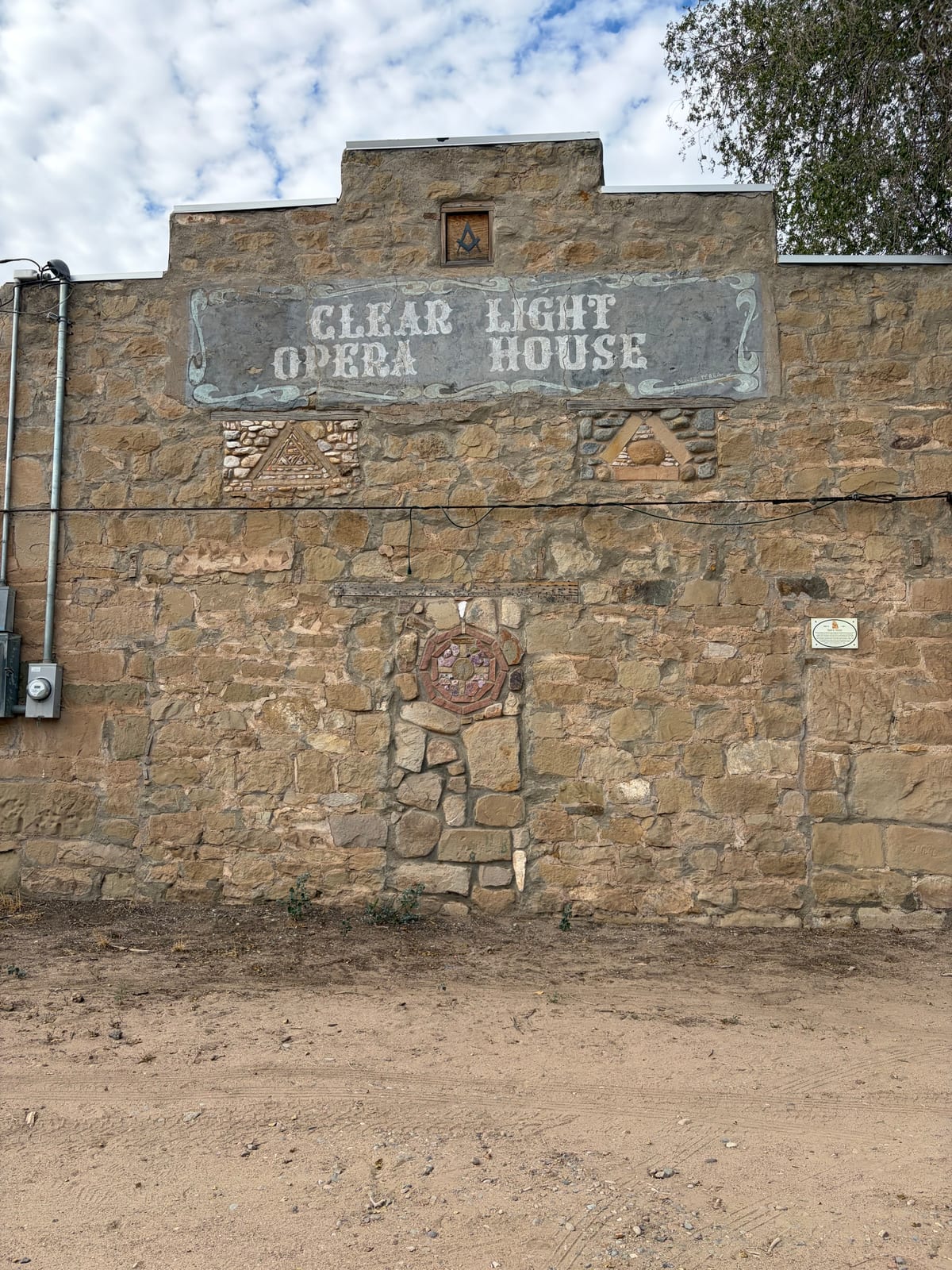 The painted Clear Light Opera House sign on a stone building in Los Cerrillos