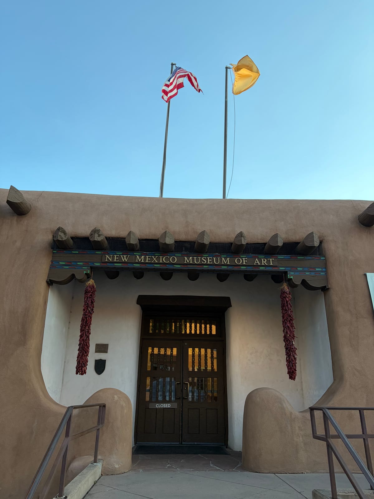 The adobe facade and carved timber entrance of the New Mexico Museum of Art