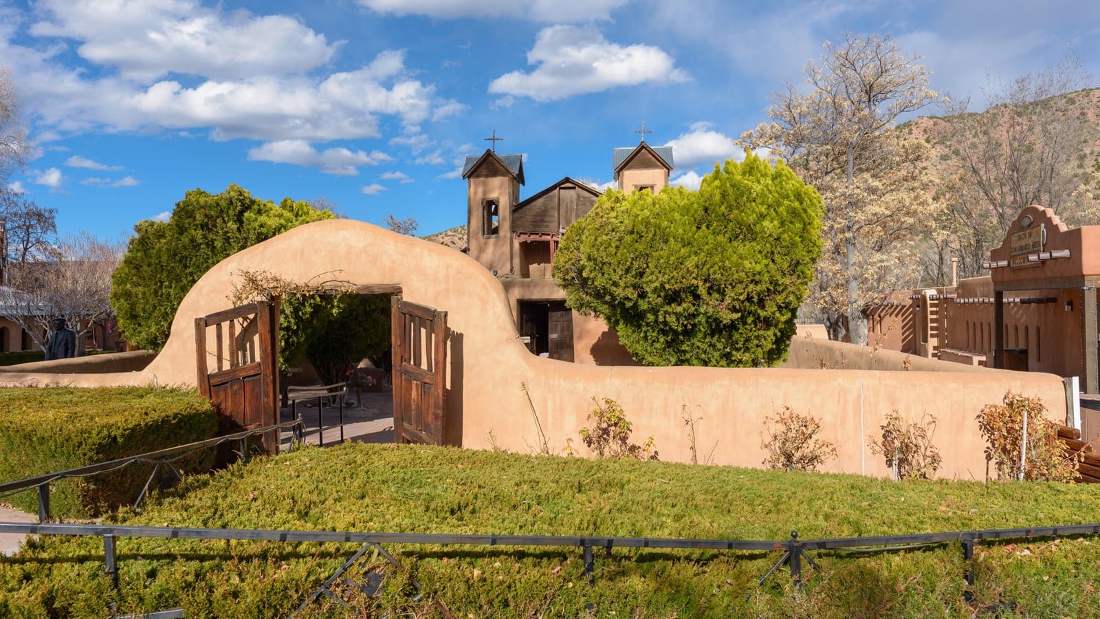 The twin-belfry adobe church and walled courtyard of El Santuario de Chimayó