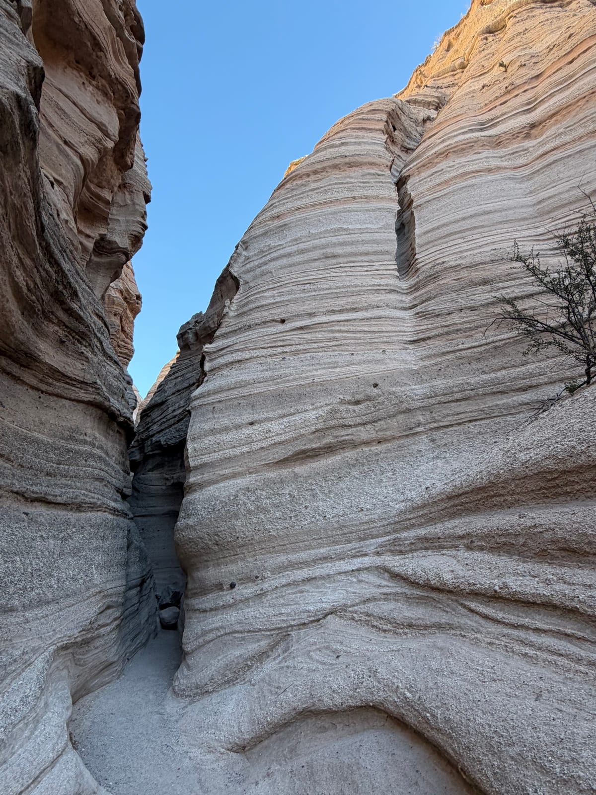 A narrow slot canyon of layered volcanic tuff at Tent Rocks