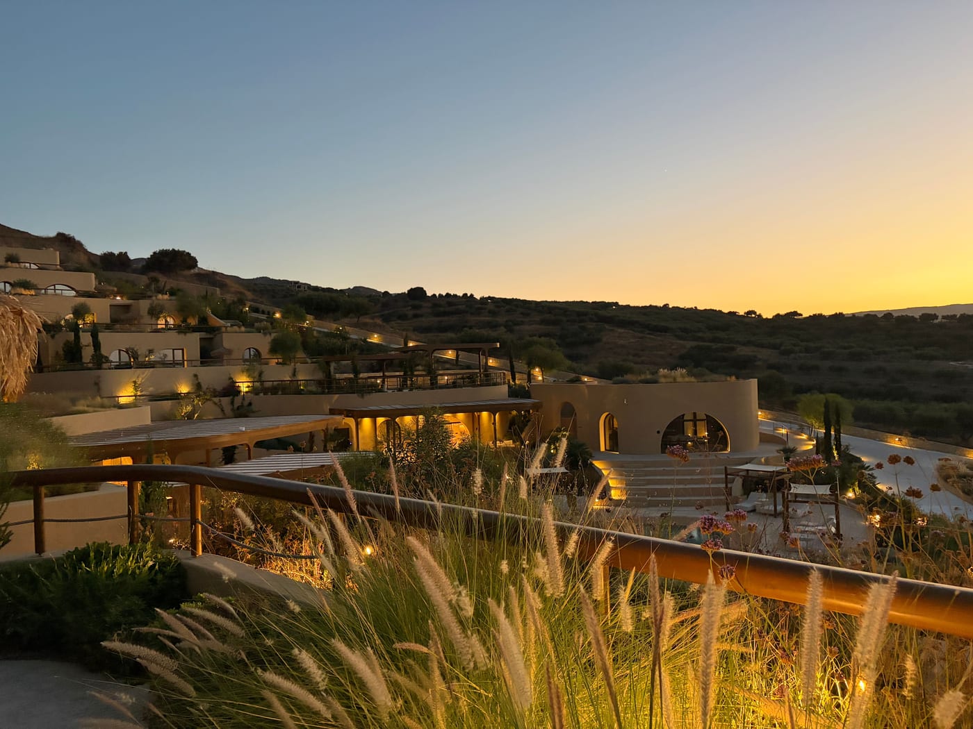 Tella Thera terraced into the Cretan hillside above olive groves at dusk
