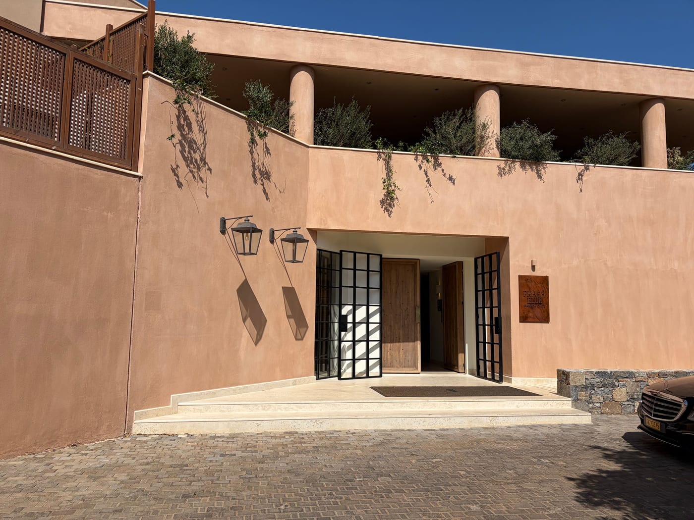 The terracotta entrance and lantern-lit doorway of Phaea Blue, Elounda